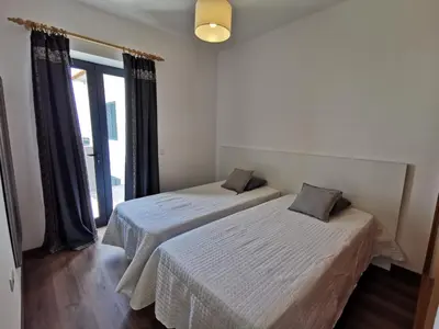 two beds in a room with a window at Lucas House in Ponta do Sol