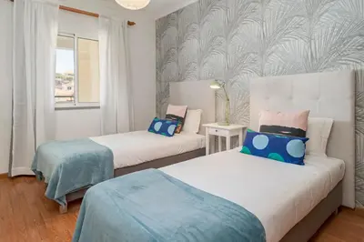 a bedroom with two beds with blue and pink at Garajau III by An Island Apart in Caniço