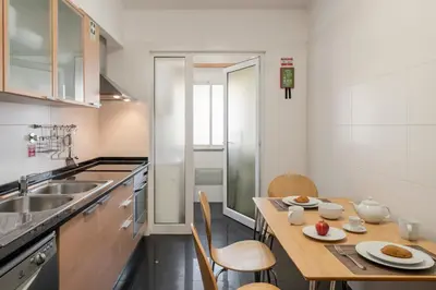 a small kitchen with a wooden table and chairs at Garajau III by An Island Apart in Caniço