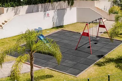 a play area with a swing set and a playground at Garajau III by An Island Apart in Caniço