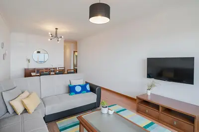 a living room with a couch and a tv at Garajau III by An Island Apart in Caniço