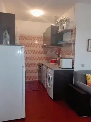 a small kitchen with a refrigerator and a microwave at Arrifana View Flat - 2km Praia Arrifana in Aljezur