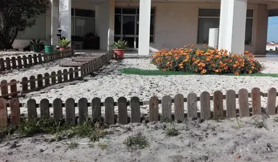 a fence in front of a house with flowers at Arrifana View Flat - 2km Praia Arrifana in Aljezur