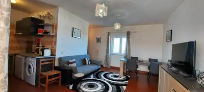 a living room with a blue couch and a television at Arrifana View Flat - 2km Praia Arrifana in Aljezur