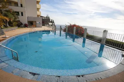 a dining room and living room with a table and chairs at Marvelous Ocean View in Funchal