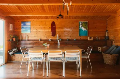 a dining room with wooden walls and tables and chairs at Aldeia Caiçara Surf House in Sagres
