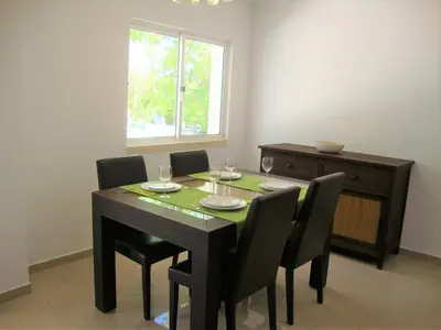 a dining room with a table and chairs and a window at Belinha Guest House in Luz