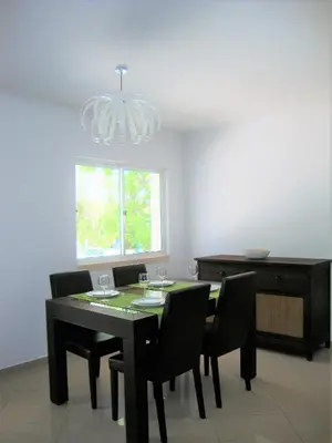 a dining room with a table and chairs and a chandelier at Belinha Guest House in Luz