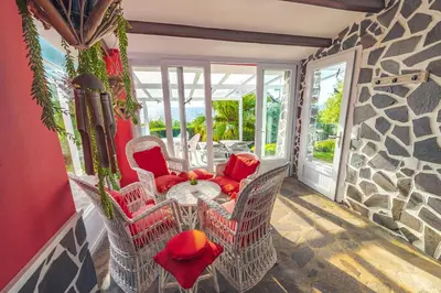 a patio with chairs and a table on a stone wall at Casa Maravilha II in Caniço