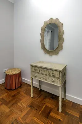 a dressing table with a mirror and a stool at Casa Maravilha II in Caniço