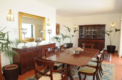 a dining room with a table and chairs and a mirror at An uninterrupted 180 overlooking the Atlantic Ocean in Caniço