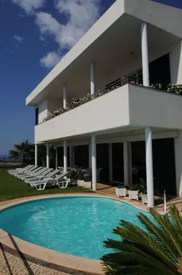 a building with a swimming pool in front of a building at An uninterrupted 180 overlooking the Atlantic Ocean in Caniço