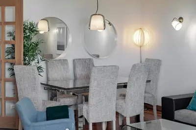 a dining room with a table and chairs and a mirror at Grand Residence I by An Island Apart in Funchal
