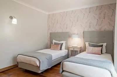 two beds in a bedroom with pink and gray walls at Grand Residence I by An Island Apart in Funchal