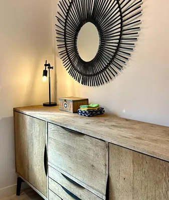 a wooden dresser with a mirror on a wall at Calheta Boutique Houses in Arco da Calheta