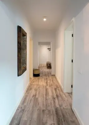 an empty hallway with white walls and wood floors at Calheta Boutique Houses in Arco da Calheta