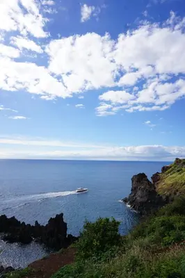 a boat in the ocean near a rocky coast at Freda House in Funchal