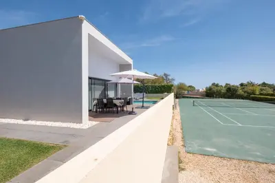a house with a tennis court and an umbrella at Bela Vista da Luz 17 by Destination Algarve in Luz