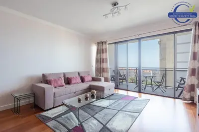 a living room with a couch and a balcony at Elegant Apartment with Sea Views by Trip2Portugal in Funchal