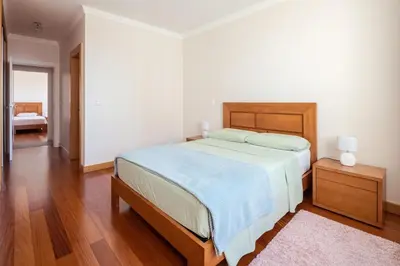 a bedroom with a large bed with a wooden headboard at Elegant Apartment with Sea Views by Trip2Portugal in Funchal
