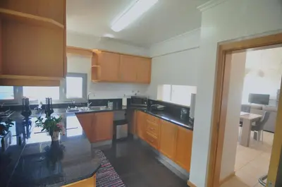 a kitchen with wooden cabinets and a black counter top at Ponte House in Porto Moniz