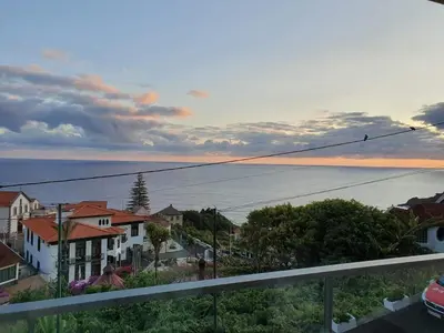 a view from a balcony of a town with the ocean at Ponte House in Porto Moniz