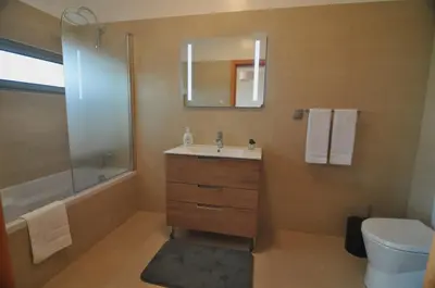 a bathroom with a sink and a toilet and a mirror at Ponte House in Porto Moniz