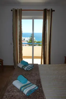 a bedroom with a bed with a view of the ocean at Casa do Mar in Salema