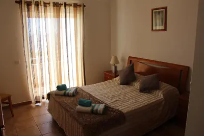 a bedroom with a bed with pillows and a window at Casa do Mar in Salema