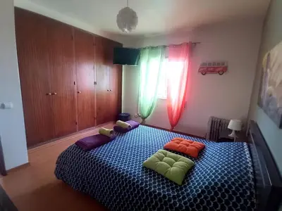 a bedroom with two beds and a dresser and a tv at CASA DIAS in Vila do Bispo