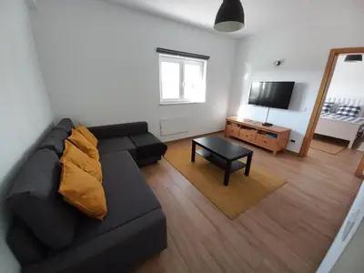 a living room with a black couch and a table at Casa Pinheirinho in Sagres