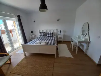 a bedroom with a bed and a desk and a mirror at Casa Pinheirinho in Sagres