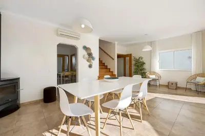 a dining room with a white table and white chairs at Lagos Beach Pool Villa in Lagos