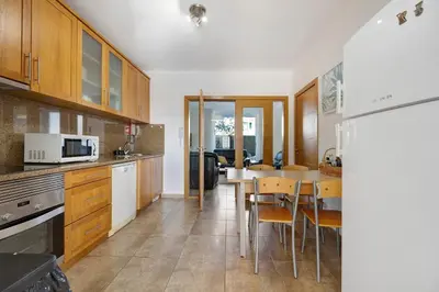 a kitchen with wooden cabinets and a table with chairs at Lagos Beach Pool Villa in Lagos