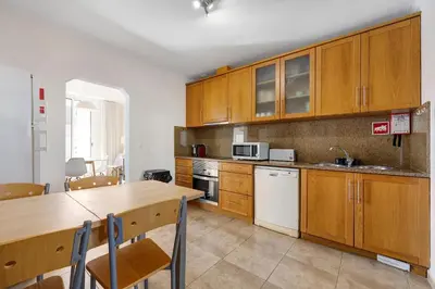 a kitchen with wooden cabinets and a wooden table at Lagos Beach Pool Villa in Lagos