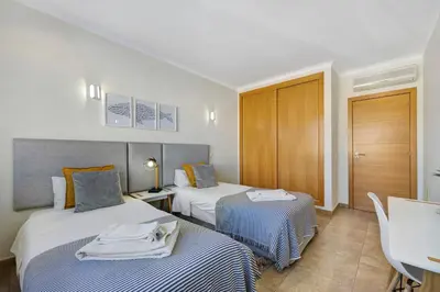 a hotel room with two beds and a table at Lagos Beach Pool Villa in Lagos