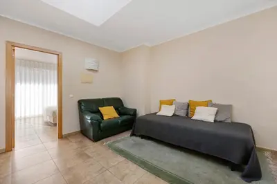 a bedroom with a bed and a green chair at Lagos Beach Pool Villa in Lagos