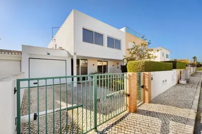 a white house with a gate and a fence at Lagos Beach Pool Villa in Lagos