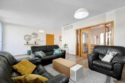 a living room with two black leather couches and a table at Lagos Beach Pool Villa in Lagos