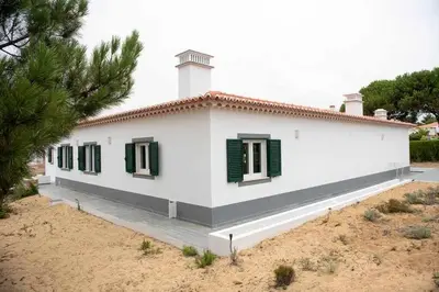 a white house with green shutters on it at Az Villa Sea e Sun in Aljezur