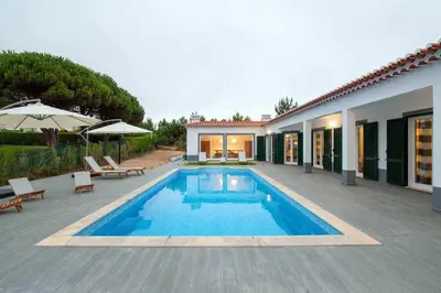 a swimming pool next to a house with a patio at Az Villa Sea e Sun in Aljezur
