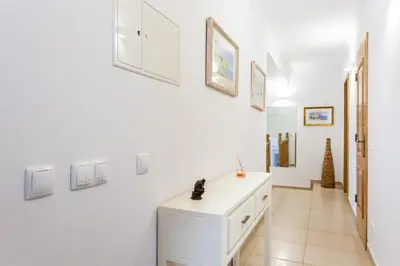 a hallway with white walls and a white dresser at Casa Bom Porto in Luz