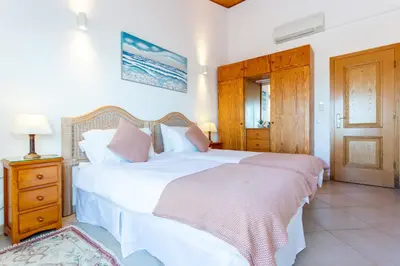 a kitchen with white cabinets and a large window at Casa Bom Porto in Luz