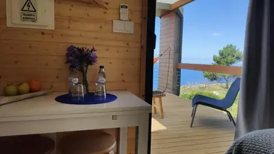 a room with a table with two bottles and a chair at Calheta Glamping Pods - Nature Retreat in Calheta