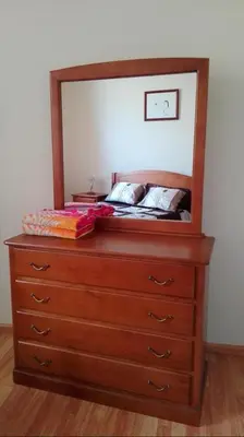 a bedroom with a dresser with a mirror on it at Apartamentos Villa in Ponta do Sol