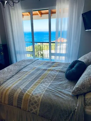 a bedroom with a bed with a view of the ocean at VILLA FELICIDADE in Arco da Calheta