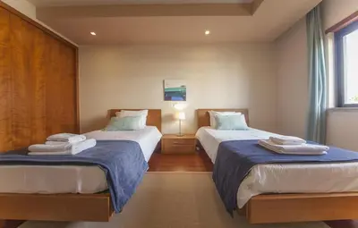 a bedroom with two beds with blue sheets at B27 - LuzBay 2 Bed Apartment in Luz