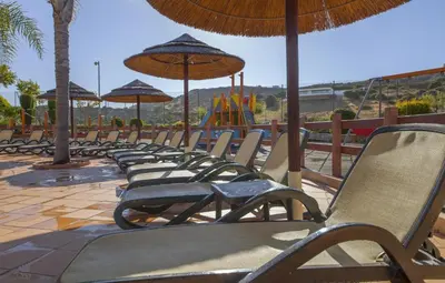 a row of chairs with umbrellas and a playground at B27 - LuzBay 2 Bed Apartment in Luz