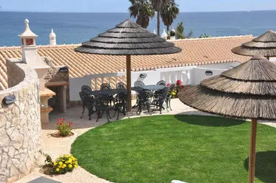 a patio with a table and chairs and umbrellas at Ocean Villas Luz in Luz