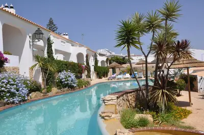 a swimming pool in a resort with palm trees at Ocean Villas Luz in Luz